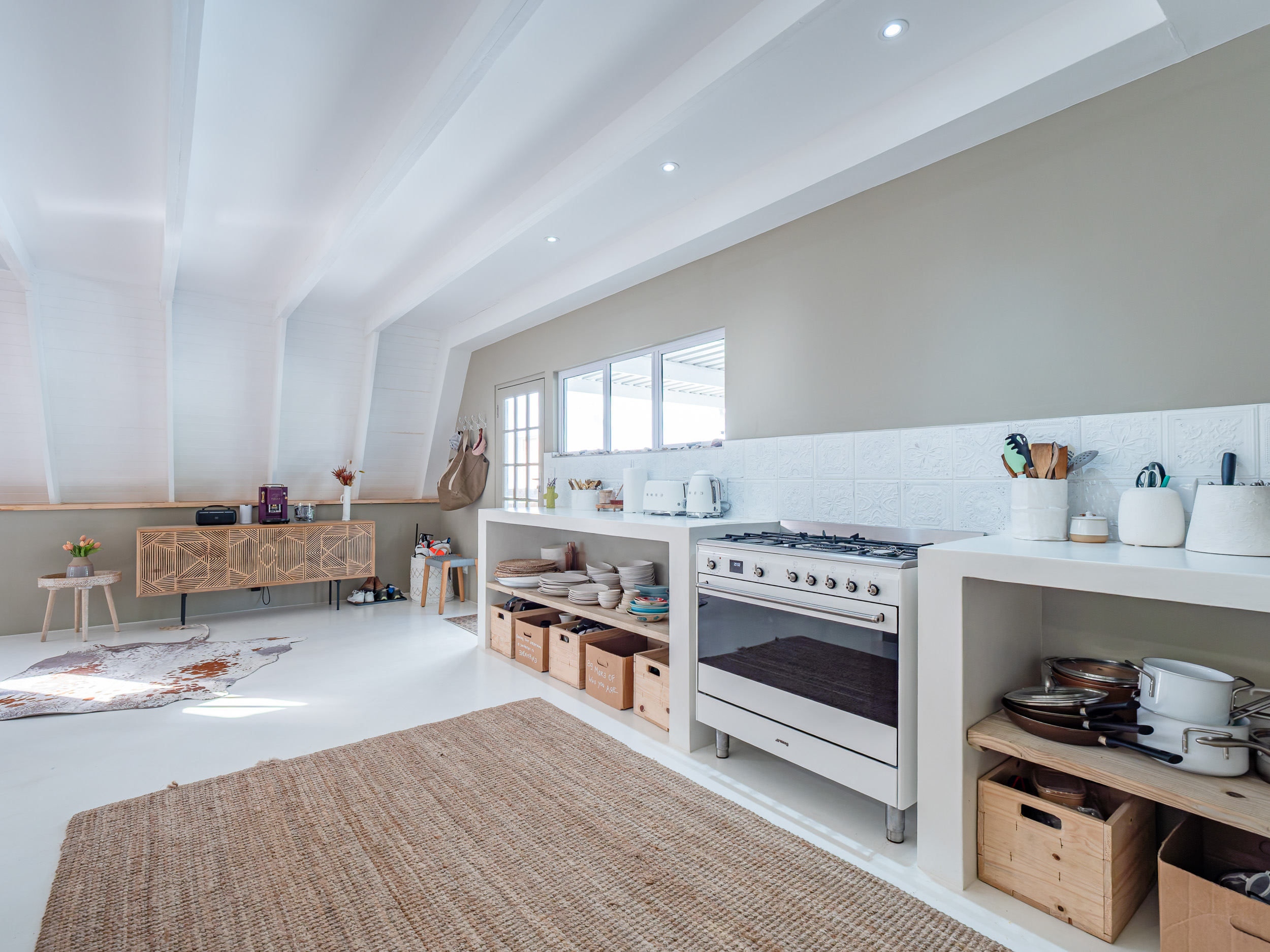 Open-plan kitchen with a gas range, open shelving and natural textures