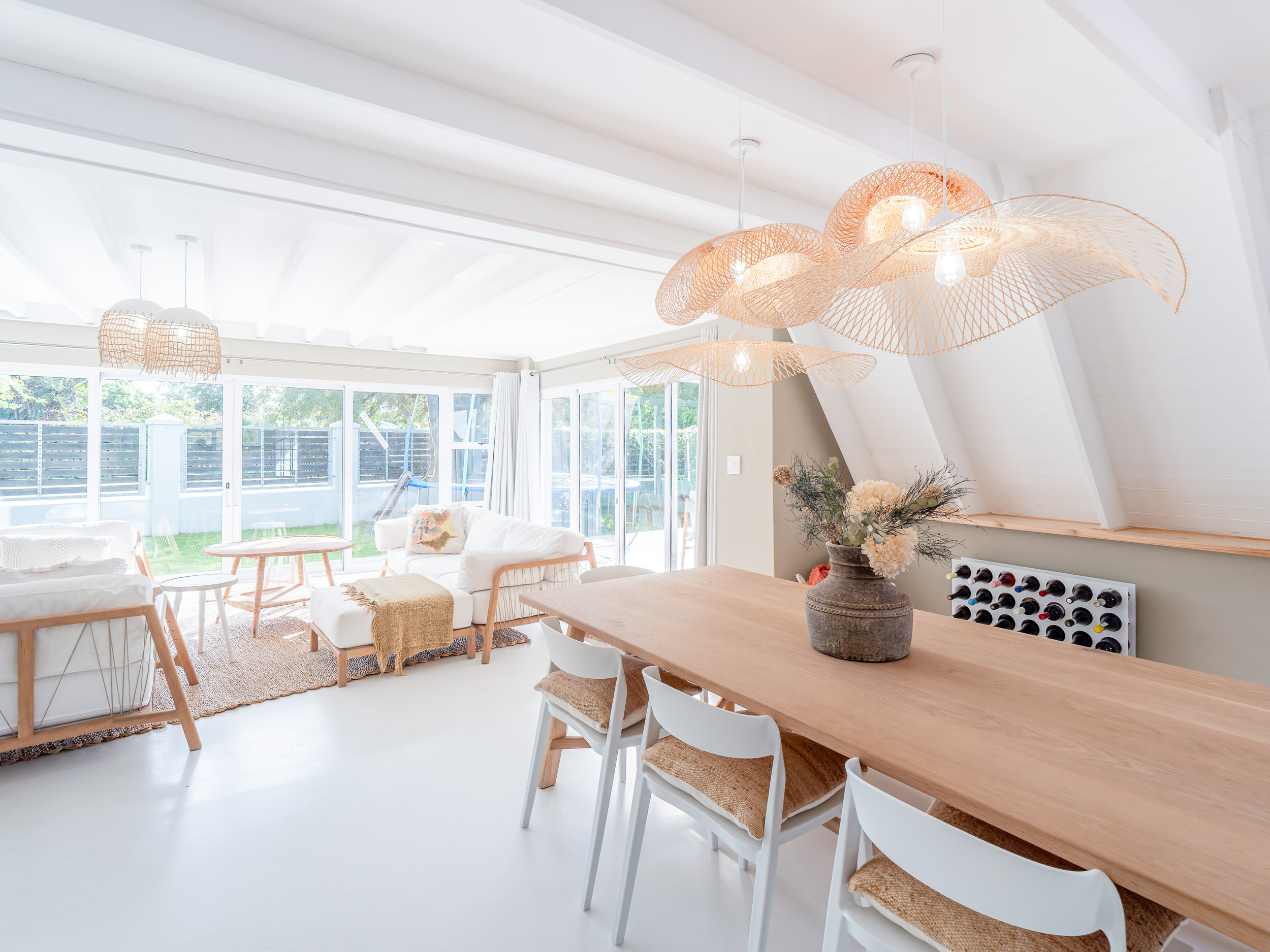 Light-filled dining room with rattan pendant and natural textures